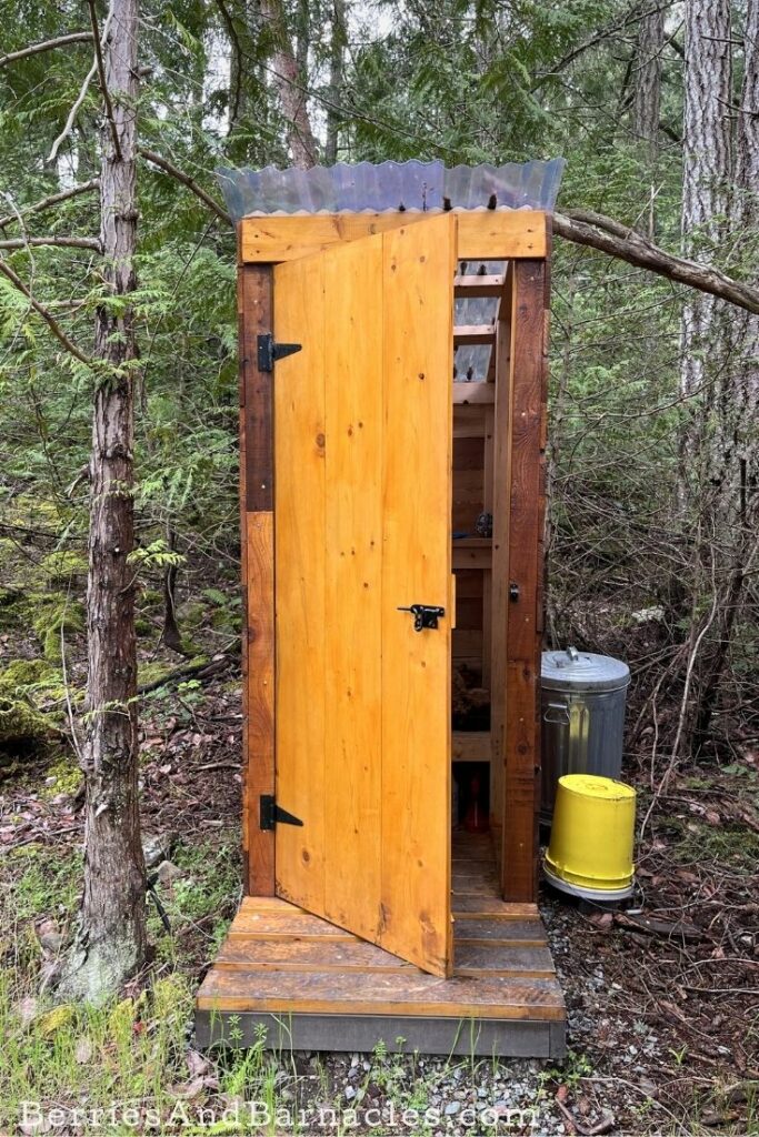 Cedar outhouse with bucket toilet.